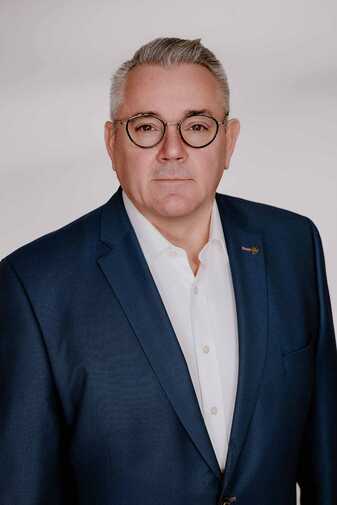 Porträtfoto von Karlheinz Knapp, Gründer und Geschäftsführer der acall Technologies GmbH, im dunkelblauen Sakko vor hellem Hintergrund.